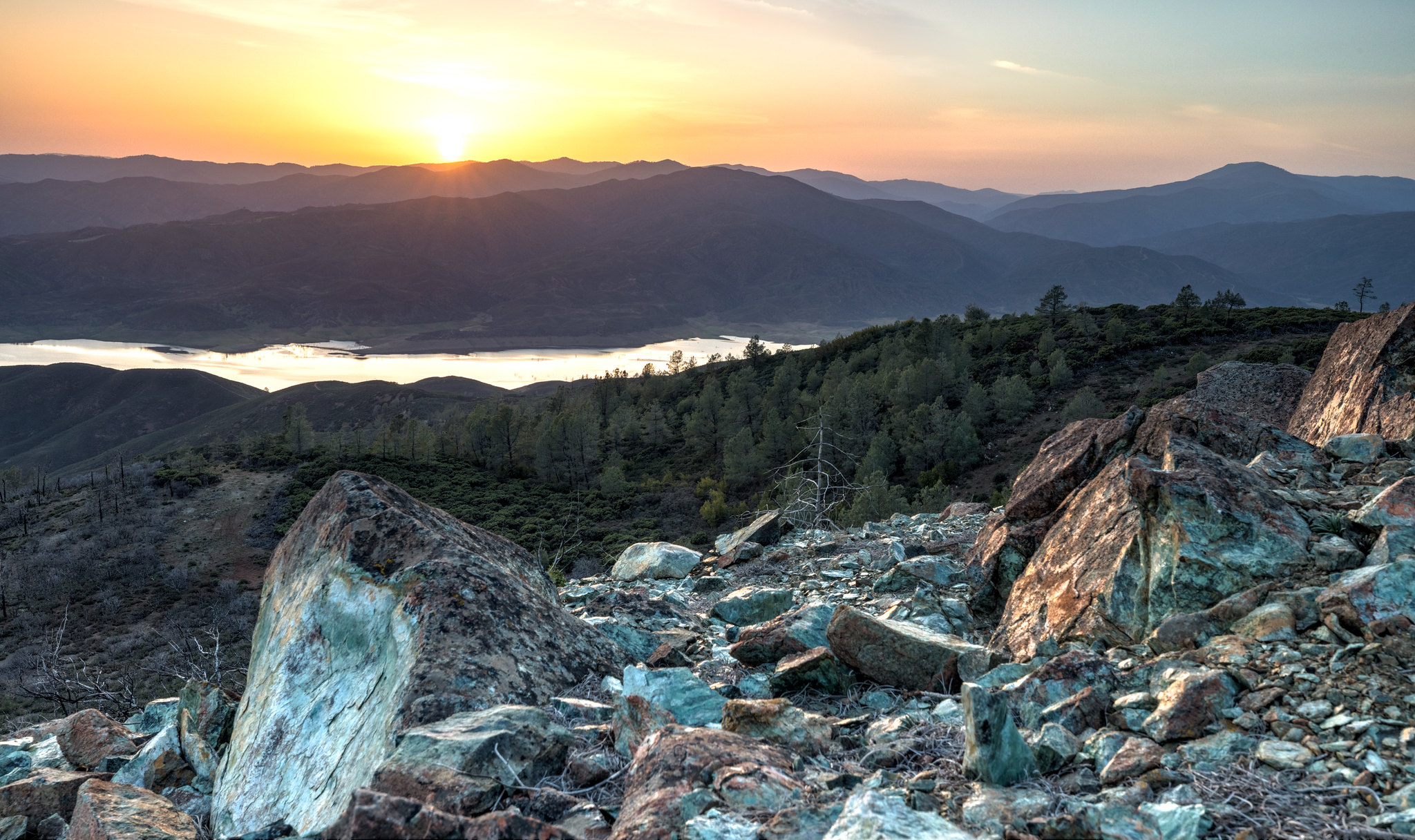 Sunset behind mountains with rocks in the foreground at Molok Luyuk aka Condor Ridge